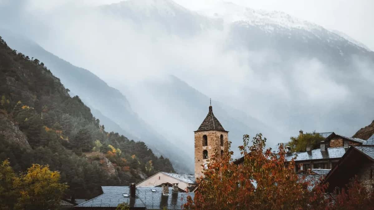 Le clocher de l'église d'Ordino se détachant sur les montagnes andorranes noyées de brume