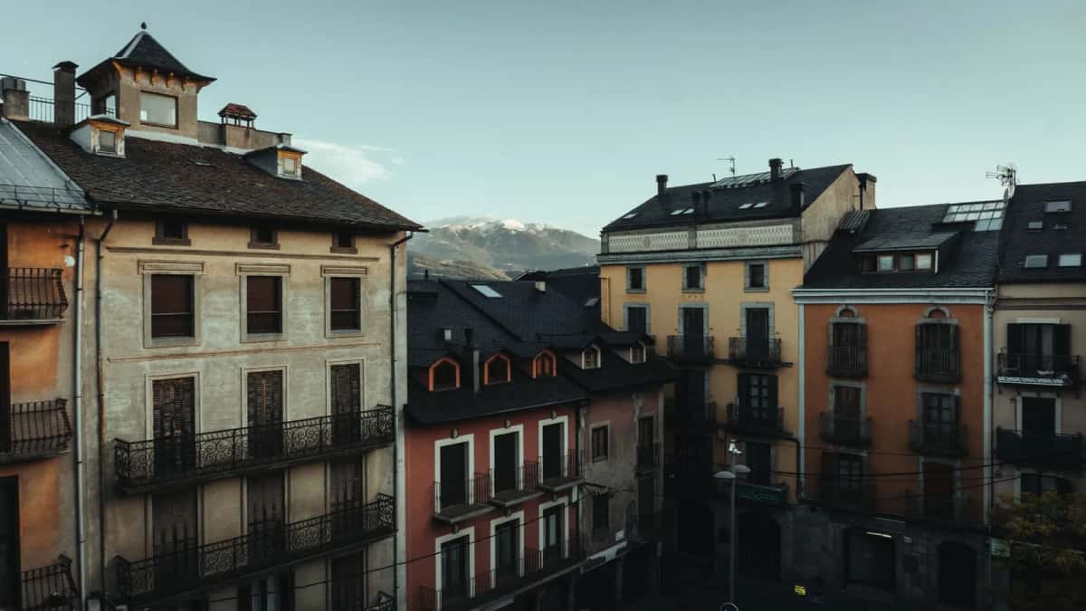 Immeubles à balcons d'une ville pyrénéenne, avec un sommet enneigé en arrière-plan