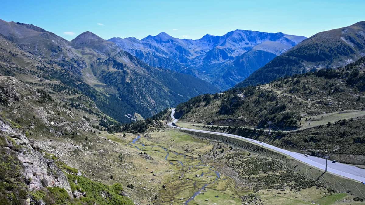 Route de montagne descendant une haute vallée des Pyrénées, seule voie d'accès entre les crêtes