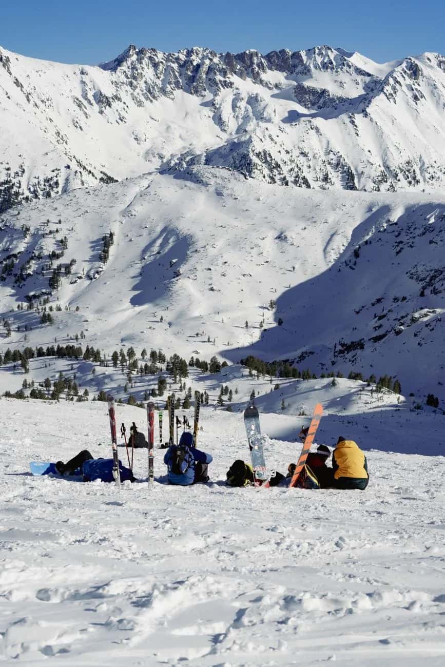 Skieurs en pause face à un cirque enneigé des Pyrénées andorranes